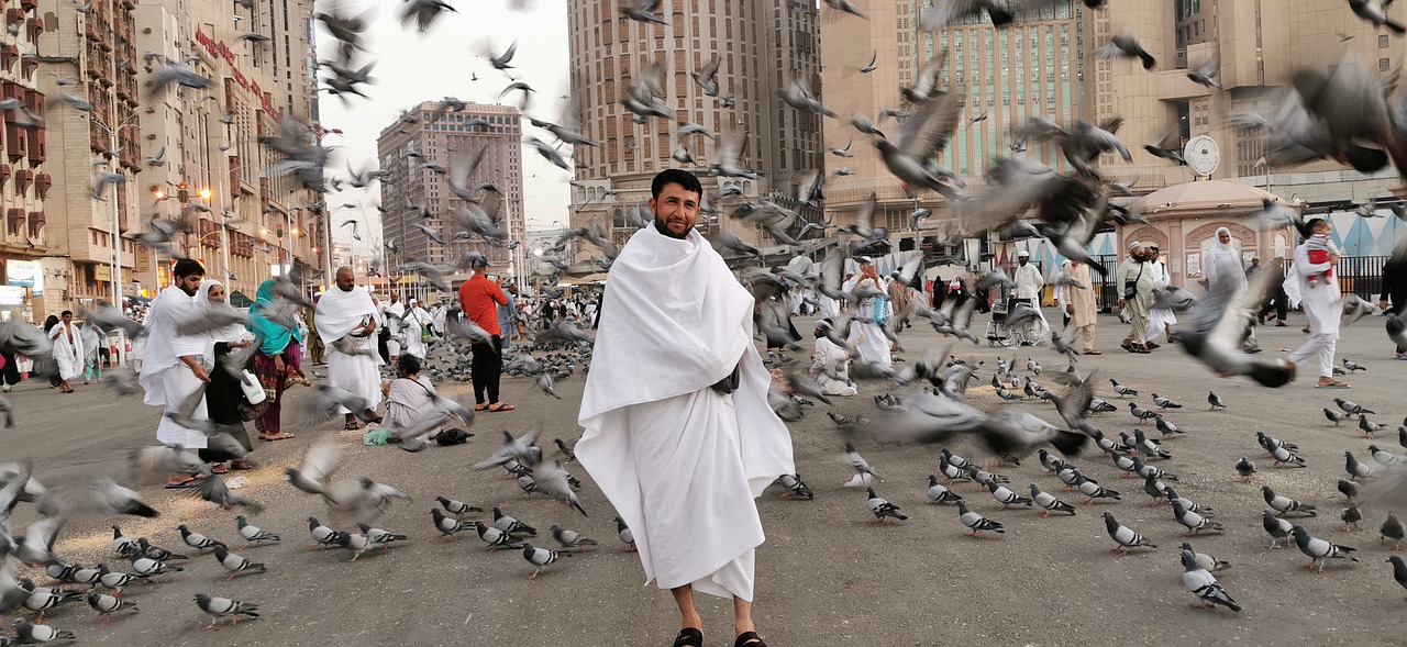 man walking in makkah around pigeon