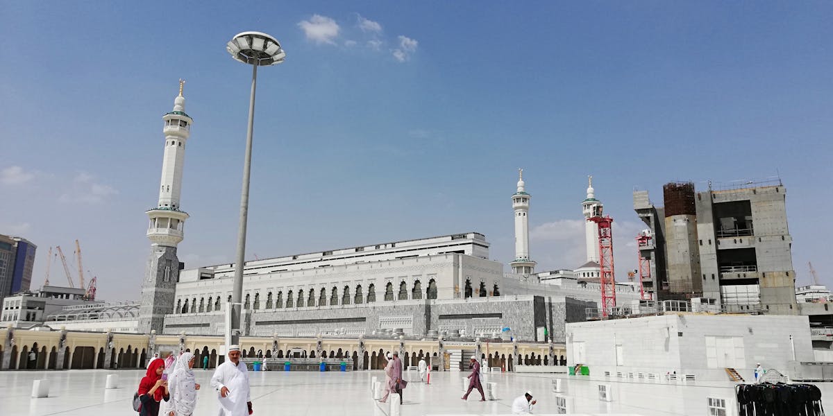 Muslim pilgrims near Masjid al-Haram on sunny day for Hajj al-Ifrad